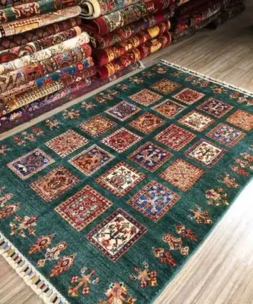 A beautiful Persian rug with a geometric design, surrounded by other folded rugs in a shop