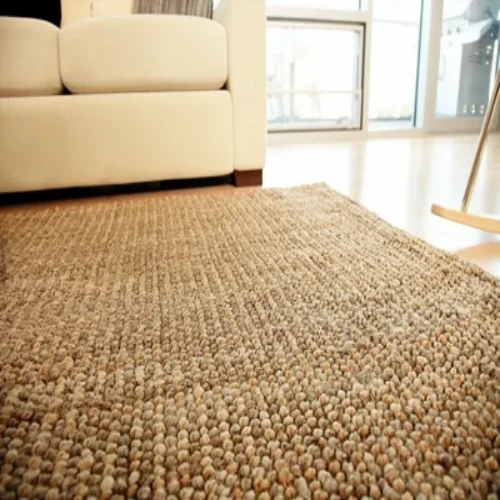 A beige sisal rugs is laid out on a hardwood floor in a modern living room