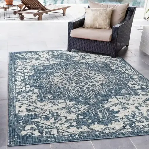 A blue and white outdoor rug with a vintage-inspired medallion pattern, perfect for a patio or deck