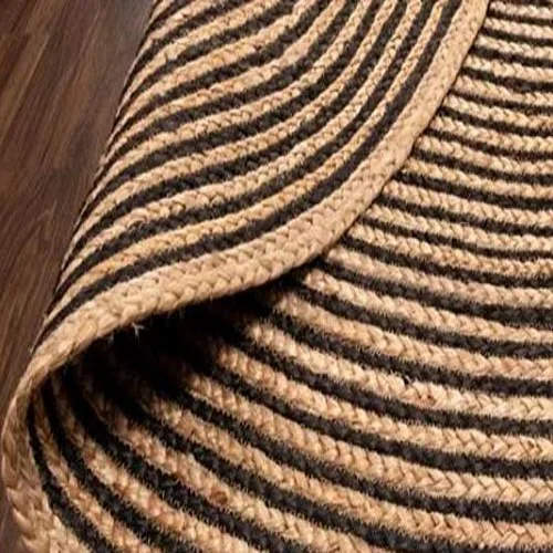 A close-up of a round jute rug with black and beige stripes