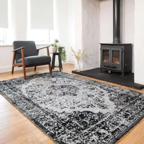 A large, black and white oriental rug with a distressed, vintage pattern