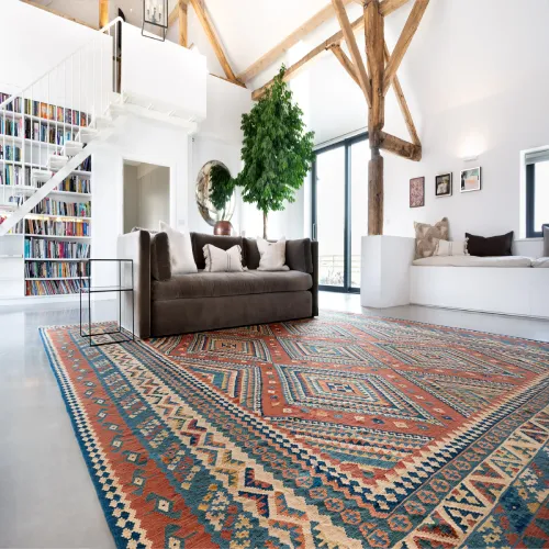 A large, colorful oriental rug with geometric patterns, placed in a spacious living room