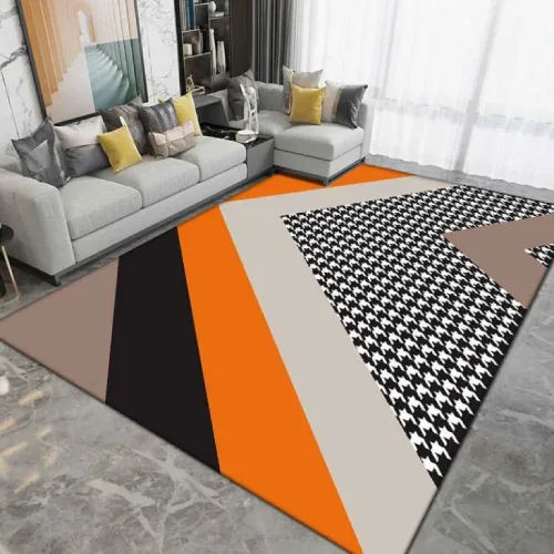 A large, contemporary area rug with a bold orange stripe and a black and white houndstooth pattern