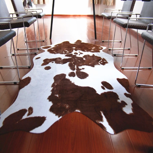 A large cowhide rug with a white base and brown spots