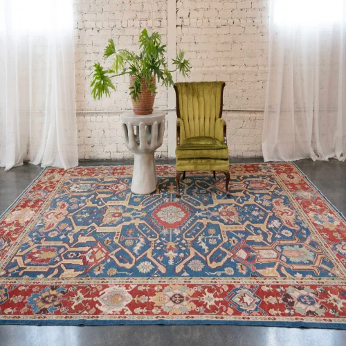 A large, intricately patterned Persian rug in shades of blue, red, and cream