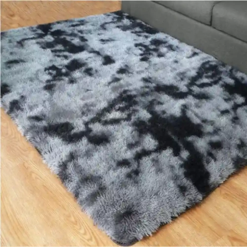 A large, shaggy gray rugs with a marbled pattern, lying on a wooden floor