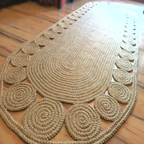 A long, oval jute runner rug with a circular pattern