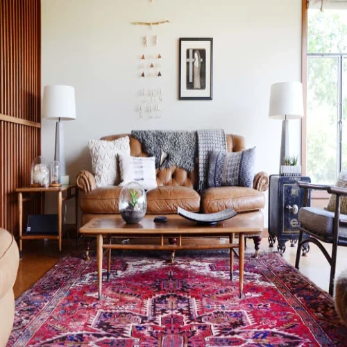 A modern living room featuring a brown leather sofa, a wooden coffee table