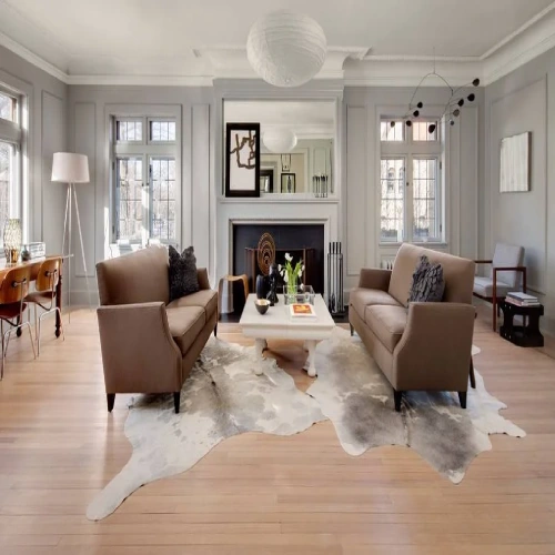 A modern living room featuring a large, animal skin rugs centered on a hardwood floor