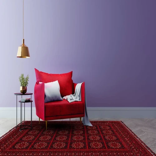 A modern living room with a red armchair, a purple wall, and a patterned Persian rug