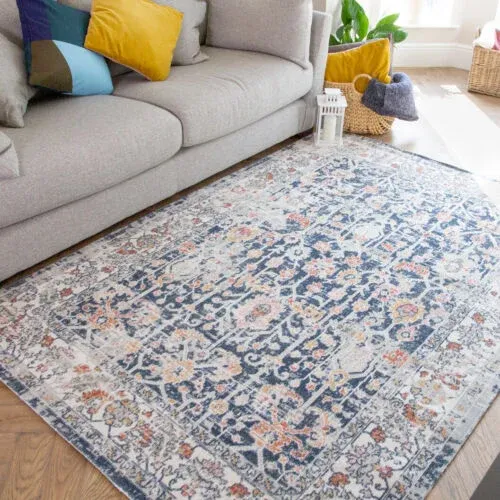 A navy blue oriental rug with a distressed, floral pattern, bordered in terracotta