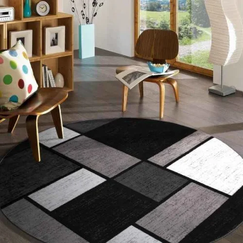 A round rug with a geometric pattern in black, white, and gray shades