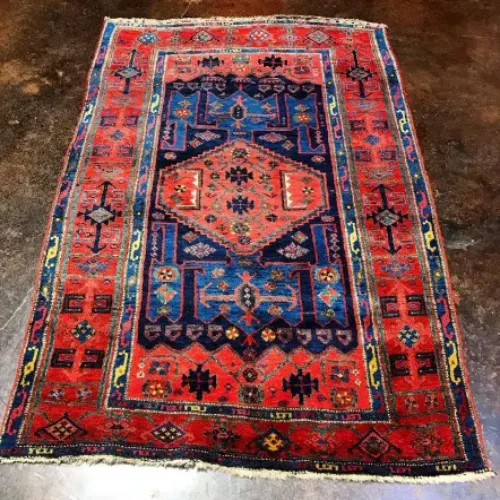 A vibrant Persian rug with a red background, intricate patterns, and shades of blue, yellow, and orange