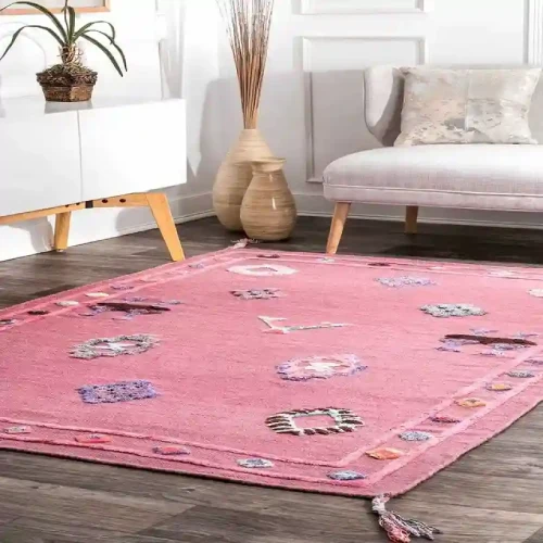 Pink Dubai area rug with a geometric pattern and fringed edges