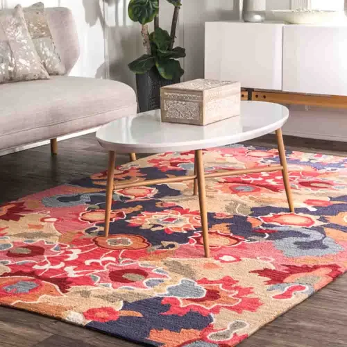 The patchwork rugs is placed in a living room setting with a white coffee table and a gray sofa.