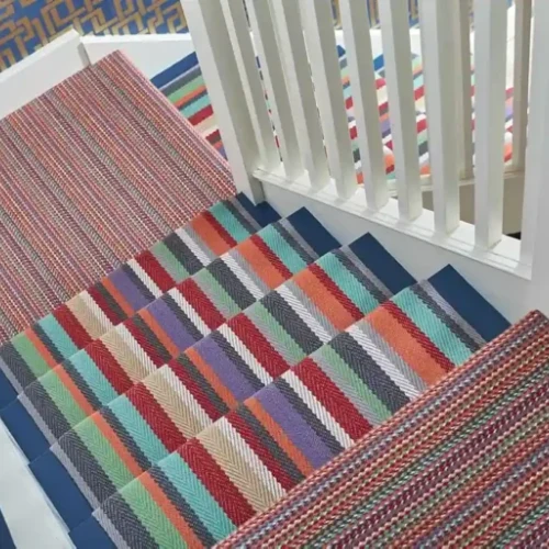 A colorful, patterned stair carpet in red, orange, yellow, green, blue, and purple