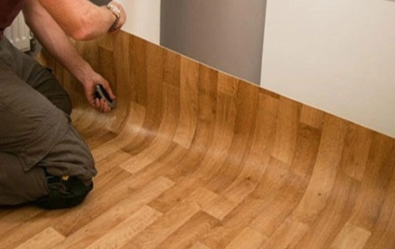 A man installing vinyl carpet in a room