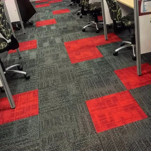 A modern office space with a bold, geometric carpet featuring red and gray squares.