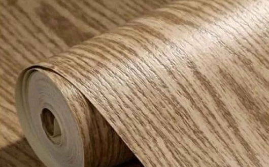 A roll of vinyl carpet with a wood grain pattern