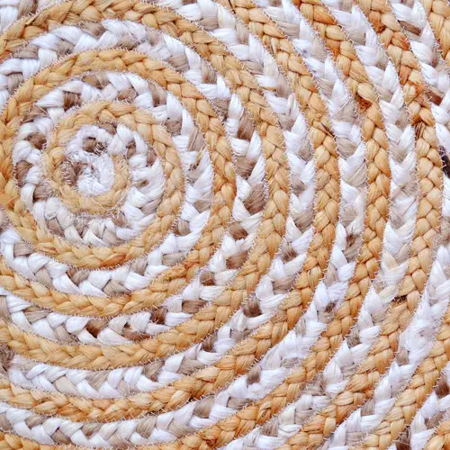 A round jute rug with a tightly braided, spiral pattern featuring